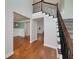 Bright foyer with hardwood floors, a staircase with rod iron spindles, and a view of the dining room at 90 Barrington Grange Dr, Sharpsburg, GA 30277