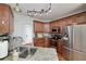 Kitchen with granite countertops, stainless steel appliances, wooden cabinets, and a view of the door at 90 Barrington Grange Dr, Sharpsburg, GA 30277