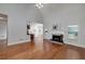 Open living room with vaulted ceilings, hardwood floors, a fireplace, and a partial view of the kitchen at 90 Barrington Grange Dr, Sharpsburg, GA 30277