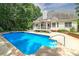 Inviting backyard oasis featuring a sparkling blue pool and covered patio, perfect for relaxation at 90 Barrington Grange Dr, Sharpsburg, GA 30277
