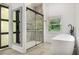 Modern bathroom featuring tiled shower with glass doors and freestanding soaking tub at 140 Indian Lake Dr, Hiram, GA 30141