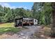 Unique home with a modern black and white exterior design nestled amongst mature trees at 140 Indian Lake Dr, Hiram, GA 30141