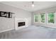 Living room featuring a fireplace, large windows, neutral carpet, and a ceiling fan at 4016 Upland Trce, Marietta, GA 30066
