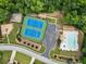 Aerial view of tennis and basketball courts, playground, and swimming pool surrounded by greenery and neighborhood streets at 4401 Madison Woods Nw Dr, Marietta, GA 30064