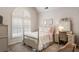Charming bedroom with an arched window, neutral walls, and a quaint vanity with an ornate mirror at 4401 Madison Woods Nw Dr, Marietta, GA 30064