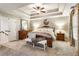 Spacious main bedroom featuring a tray ceiling, neutral tones, and a seating area at 4401 Madison Woods Nw Dr, Marietta, GA 30064