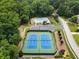 Aerial view of community tennis courts with swimming pool and parking surrounded by lush greenery at 4401 Madison Woods Nw Dr, Marietta, GA 30064