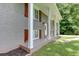 Front exterior showing gray brick, white pillars and trim, and a well-kept lawn at 1863 Rockford Ct, Riverdale, GA 30296