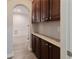 A hallway with dark cabinets and light counter near arched entryway at 2940 Bentbill Xing, Cumming, GA 30041