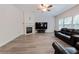 Bright living room features a fireplace, ceiling fan, and a comfortable black leather sofa at 2940 Bentbill Xing, Cumming, GA 30041