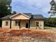Charming single-story home features neutral siding, a welcoming front porch, and complementary shutters at 389 Campground School Rd, Dallas, GA 30157