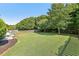 Spacious backyard featuring a lush lawn, mature trees, and a patio area at 4020 Emerald Glade Ct, Cumming, GA 30040