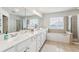 Bright bathroom with double sinks, tile flooring, and separate tub and shower at 4020 Emerald Glade Ct, Cumming, GA 30040