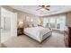 Bedroom featuring a king bed, neutral walls, and a tray ceiling with a fan at 4020 Emerald Glade Ct, Cumming, GA 30040