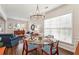 Dining room with a glass table set for four and views into the adjacent living room at 4020 Emerald Glade Ct, Cumming, GA 30040