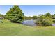 Scenic community pond surrounded by mature trees and manicured lawns offers a serene setting for residents at 4020 Emerald Glade Ct, Cumming, GA 30040