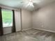 Bedroom with neutral walls, carpet flooring, ceiling fan, and window with wooded exterior views at 1035 Towne Manor Nw Ct, Kennesaw, GA 30144