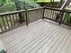 Wooden deck with brown railing, offering views of the surrounding wooded backyard at 1035 Towne Manor Nw Ct, Kennesaw, GA 30144