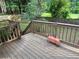 View of the wooden deck with brown railing and surrounding wooded backyard and partial fence at 1035 Towne Manor Nw Ct, Kennesaw, GA 30144