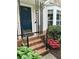 Cozy front porch with brick steps, iron railings, and a blue front door at 1035 Towne Manor Nw Ct, Kennesaw, GA 30144