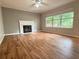 Spacious living room featuring hardwood floors, a fireplace, large windows, and a ceiling fan at 1035 Towne Manor Nw Ct, Kennesaw, GA 30144