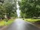 Street view of a quiet neighborhood with mature trees and well-maintained lawns at 1035 Towne Manor Nw Ct, Kennesaw, GA 30144