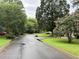 Scenic street view of a neighborhood lined with lush greenery and flowering trees at 1035 Towne Manor Nw Ct, Kennesaw, GA 30144