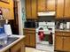 Functional kitchen with white appliances, wooden cabinets, and a sink with a view at 1109 Granite Ln, Loganville, GA 30052