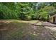 Spacious and private backyard surrounded by mature trees, featuring a deck and room to enjoy at 1729 Norden Rd, Riverdale, GA 30296