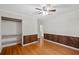Bedroom with an open closet, hardwood floors, and decorative wood accent walls at 1729 Norden Rd, Riverdale, GA 30296