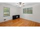 Bright bedroom featuring hardwood floors, two windows, and a ceiling fan at 1729 Norden Rd, Riverdale, GA 30296