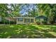 Charming one-story home with yellow brick, blue trim, mature trees, and a well-manicured lawn at 1729 Norden Rd, Riverdale, GA 30296