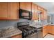 Kitchen featuring black appliances, light wood cabinets, and gray laminate countertops at 1729 Norden Rd, Riverdale, GA 30296