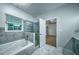 Modern bathroom showcasing a soaking tub, glass shower, and updated gray finishes at 220 Chandler Ct, Sugar Hill, GA 30518