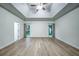 Large bedroom boasts bright windows, fan, and beautiful gray wood flooring at 220 Chandler Ct, Sugar Hill, GA 30518