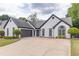 Charming brick home features a well-manicured lawn and a driveway at 220 Chandler Ct, Sugar Hill, GA 30518