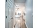 Hallway view of an open kitchen with white cabinetry and wood flooring leading to a backyard view at 220 Chandler Ct, Sugar Hill, GA 30518