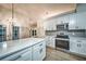 Bright kitchen with quartz countertops, stainless appliances, gray backsplash, and light wood-look floors at 220 Chandler Ct, Sugar Hill, GA 30518