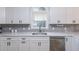Kitchen features white cabinets, gray subway tile backsplash, and stainless steel appliances at 220 Chandler Ct, Sugar Hill, GA 30518