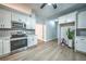 Well-lit kitchen with stainless appliances, white cabinets, gray tile backsplash, and wood-look floors at 220 Chandler Ct, Sugar Hill, GA 30518