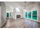 Bright living room featuring a fireplace, chandelier, updated flooring, and large windows for natural light at 220 Chandler Ct, Sugar Hill, GA 30518