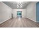 Spacious living room features modern lighting, vaulted ceilings, and beautiful gray wood flooring at 220 Chandler Ct, Sugar Hill, GA 30518