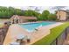 Community pool with a covered seating area, lush grass and an iron fence at 220 Chandler Ct, Sugar Hill, GA 30518