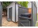 Backyard shed with double doors and neutral paint scheme, stone path and wood fencing at 220 Chandler Ct, Sugar Hill, GA 30518