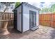 Backyard shed with double doors and neutral paint scheme, stone path and wood fencing at 220 Chandler Ct, Sugar Hill, GA 30518