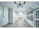 Bright sunroom with white wainscoting, gray floors, a ceiling fan, and lots of windows at 220 Chandler Ct, Sugar Hill, GA 30518