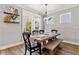 Cozy dining area with a rustic wooden table, bench seating, and natural light streaming in from the door at 338 Boundless Ln, Canton, GA 30114