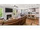 Open-concept living room featuring a fireplace, hardwood floors, and modern kitchen with stainless steel appliances at 338 Boundless Ln, Canton, GA 30114