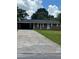 Charming single-story brick home with a long driveway and attached carport, nestled among mature trees at 6192 Meadowbrook Dr, Norcross, GA 30093