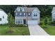 Charming two-story home featuring gray brick, a two-car garage, manicured lawn and a welcoming front porch at 5090 Bellehurst Ln, Cumming, GA 30040